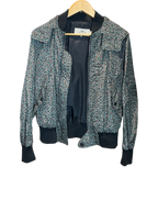 Modify Thrift vintage Coach hooded bomber jacket with teal, pink, and olive ditsy floral print and dark ribbed trim.
