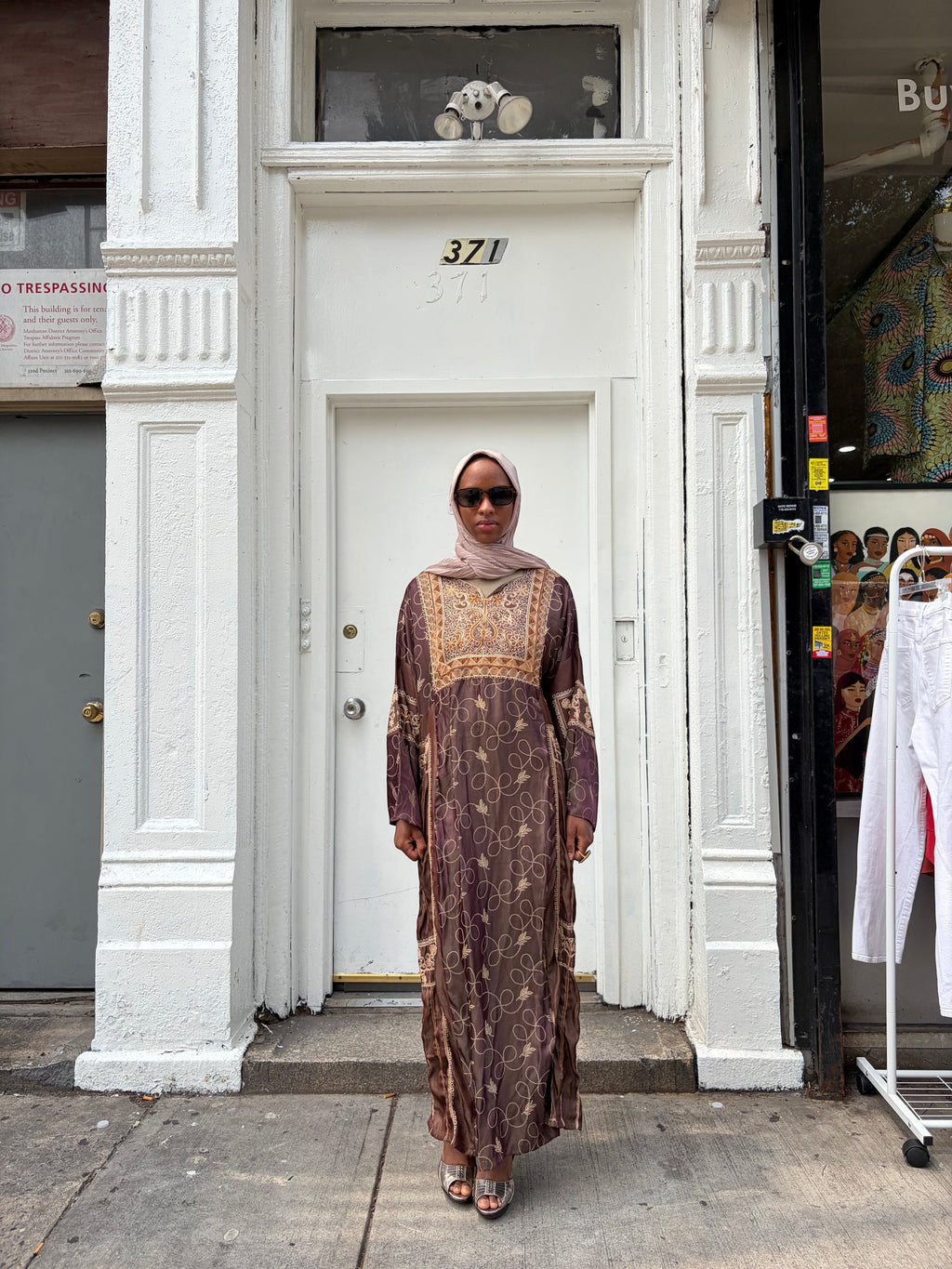 Modify Thrift chocolate brown silk-satin maxi dress with gold vine embroidery worn by a woman in a hijab and glasses.
