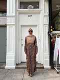 Modify Thrift chocolate brown silk-satin maxi dress with gold vine embroidery worn by a woman in a hijab and glasses.
