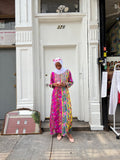 Modify Thrift model wearing a vibrant floral and paisley maxi kaftan with embroidered bib and pink glasses