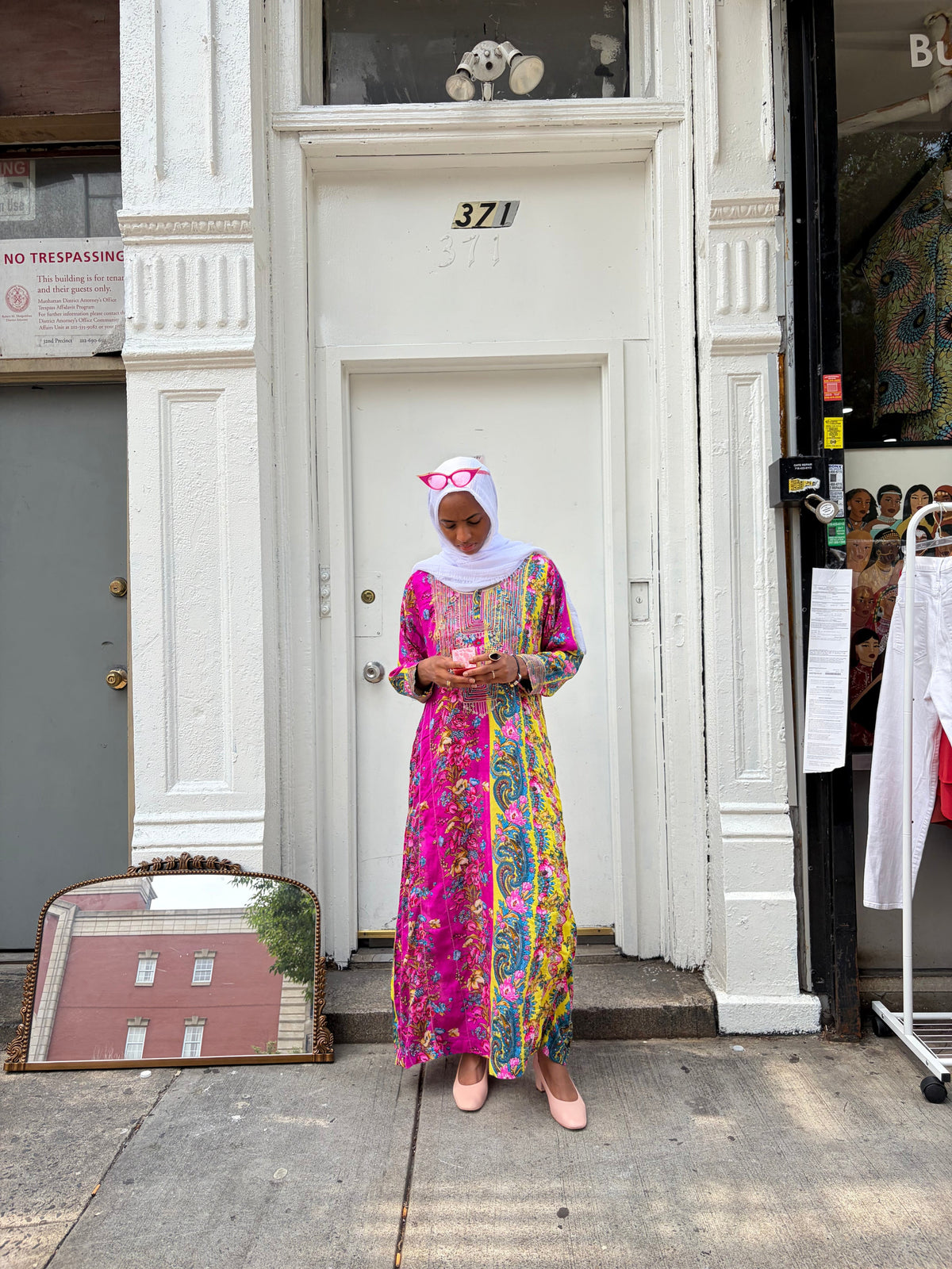 Modify Thrift model wearing a vibrant floral and paisley maxi kaftan with embroidered bib and pink glasses