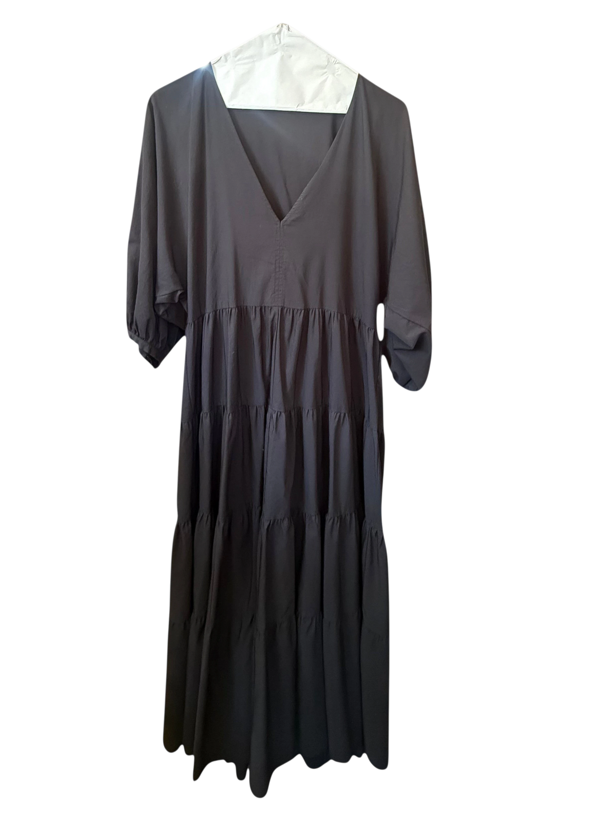 Modify Thrift Zara jet black tiered midi dress with V-neck and three-quarter puff sleeves hanging in a boutique.