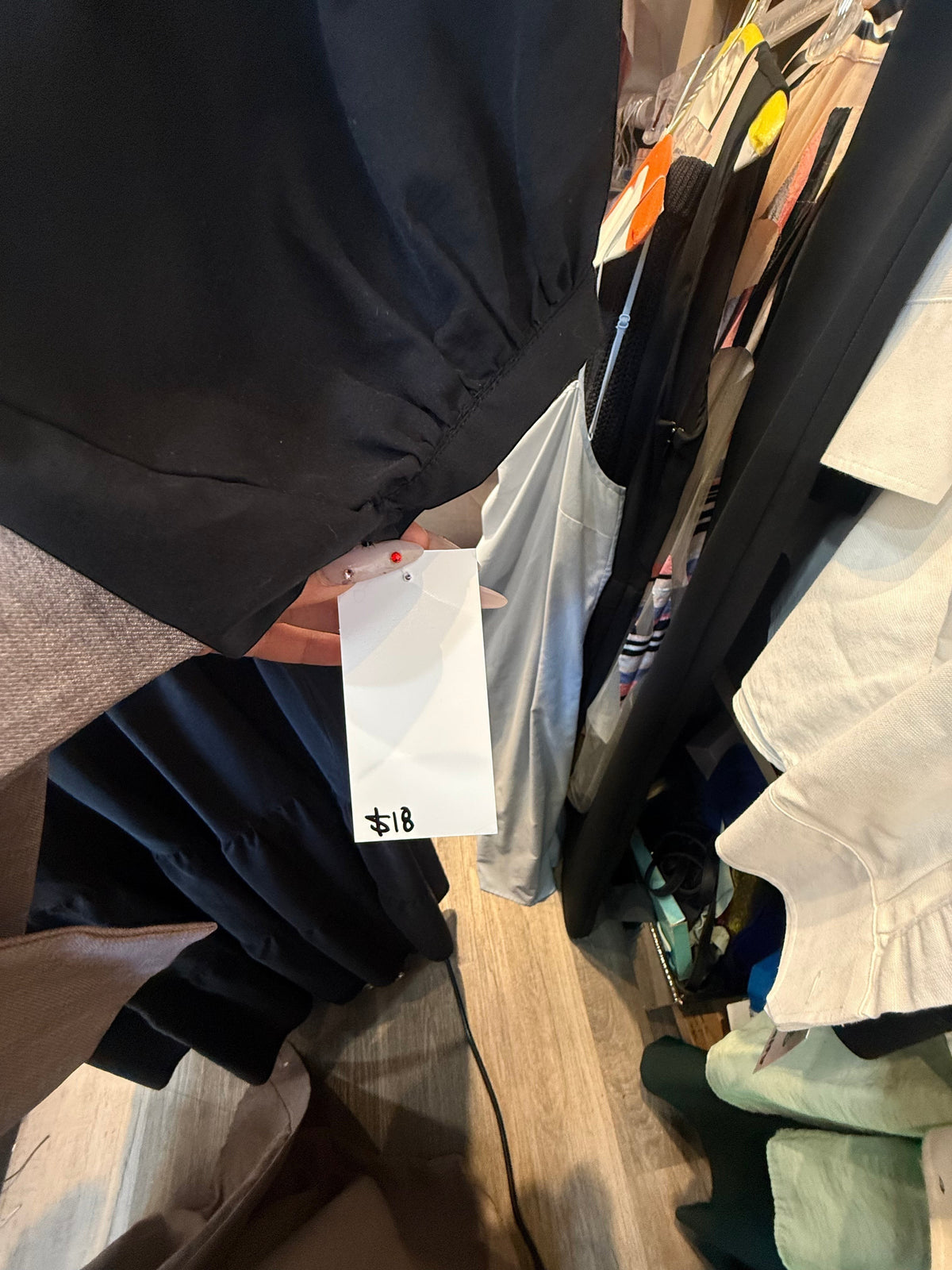 Modify Thrift Zara jet black tiered midi dress with three-quarter puff sleeves and gathered cuffs on a clothing rack